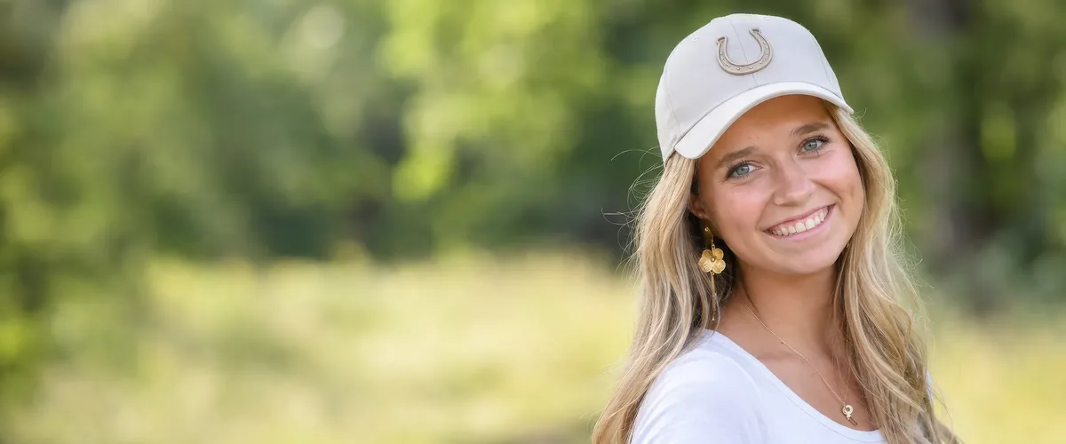 Frau mit heller bestickter Cap im Freien